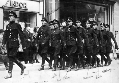 97836 Afbeelding van een groep marcherende politieagenten op de Oudegracht te Utrecht ter hoogte van de huizen nrs. 131 ...